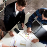 Small business owners sitting around a table analyzing financial reports